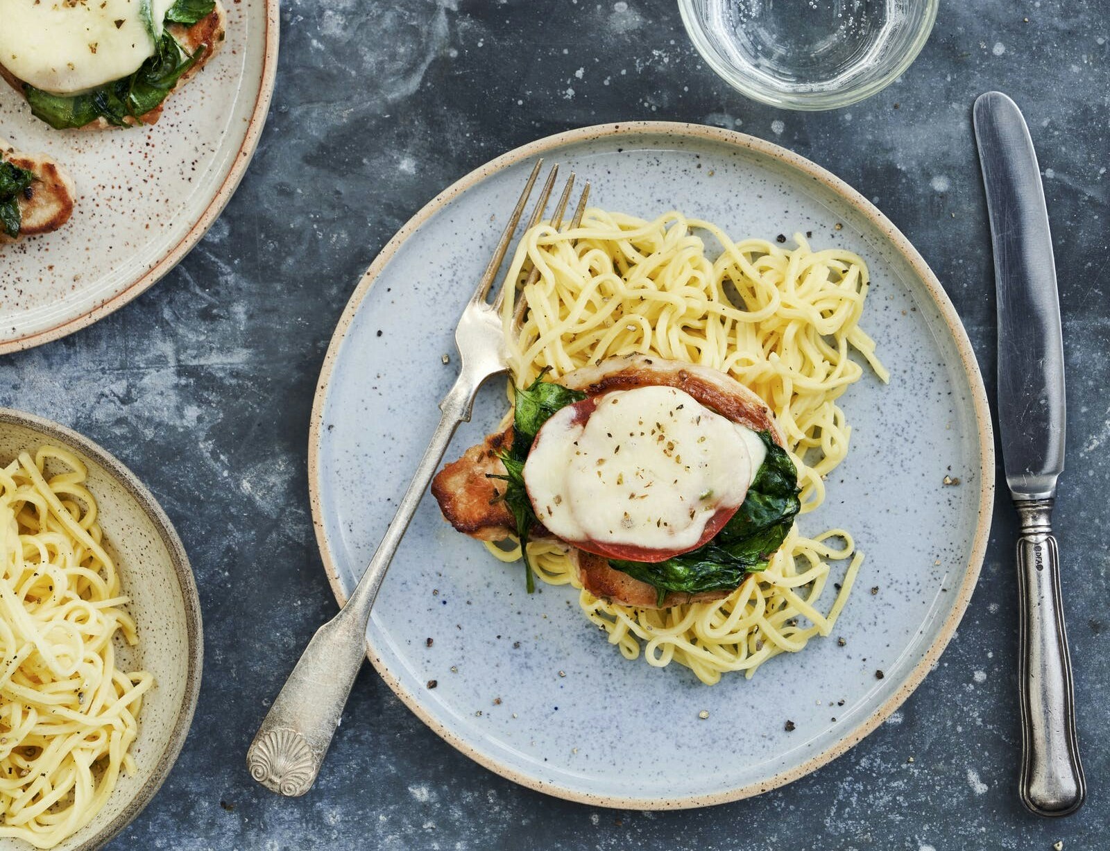 Italienske koteletter i fad med spinat, tomat og mozzarella