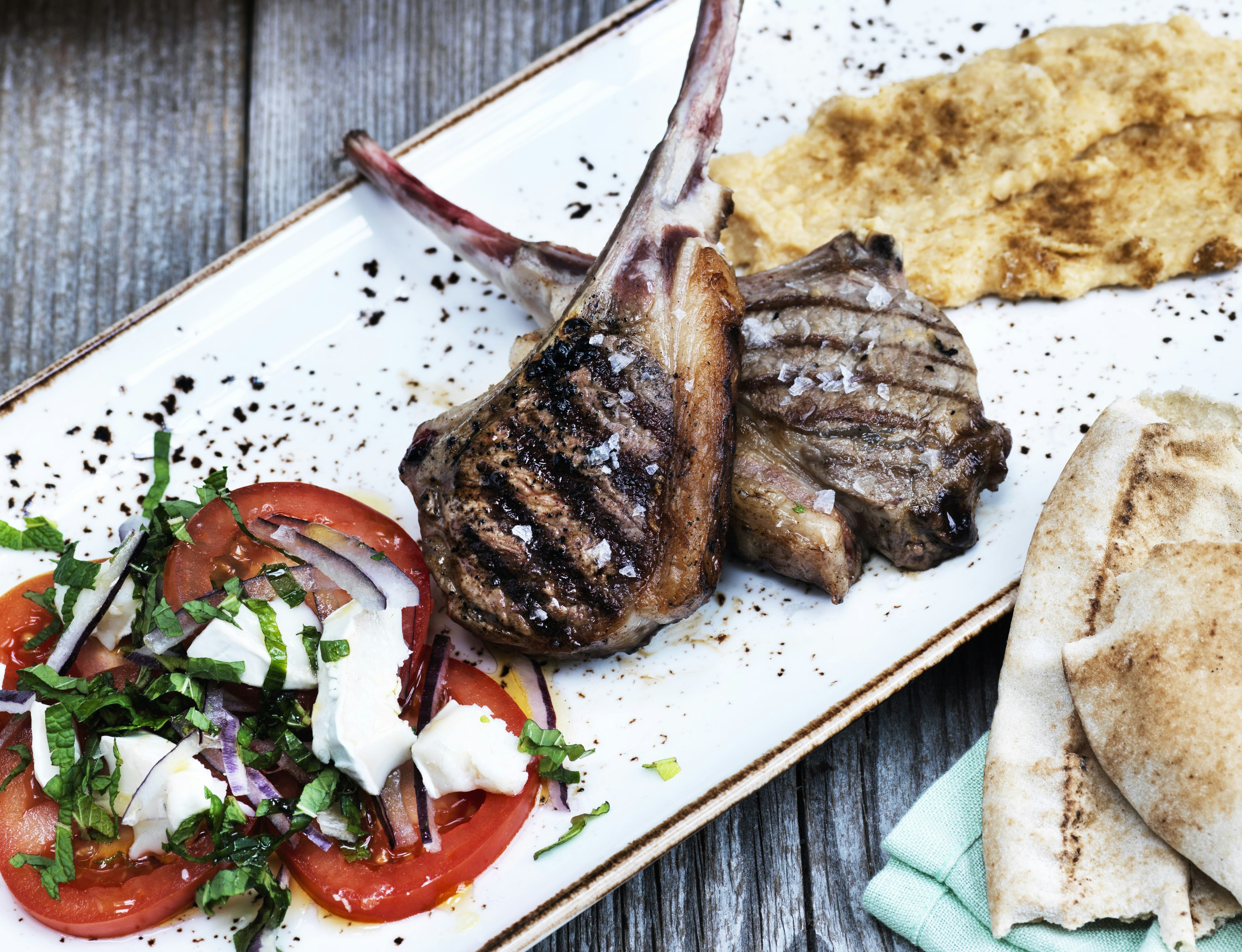 Lammekoteletter med krydret kikærtemos og tomatsalat