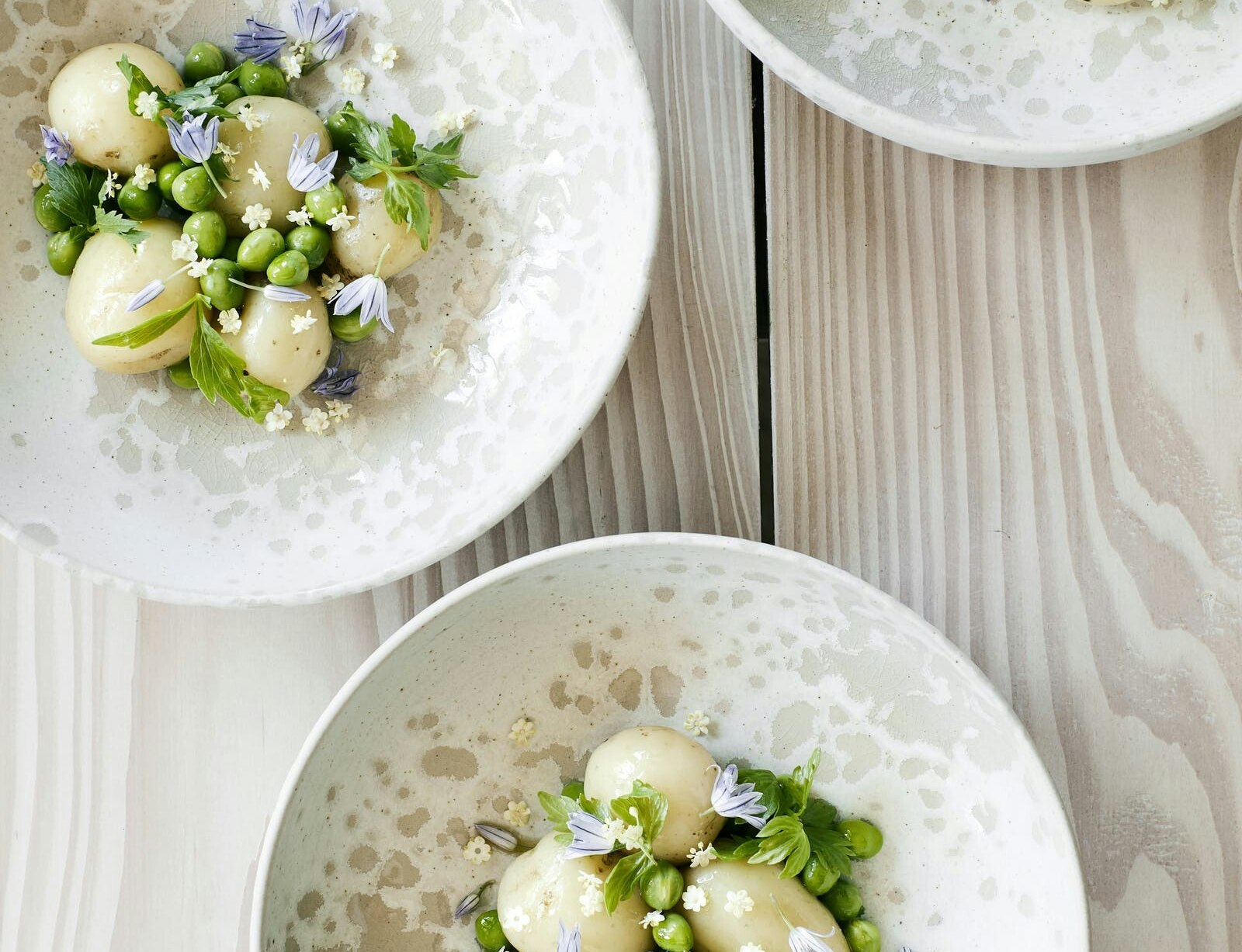 Nye kartofler med ærter, løvstikke og hyldeblomst