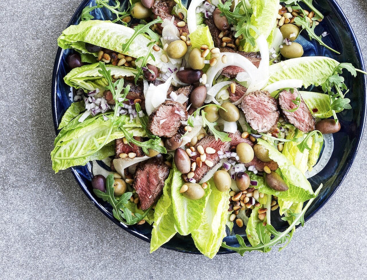 Oksekødssalat med oliven og ristede pinjekerner