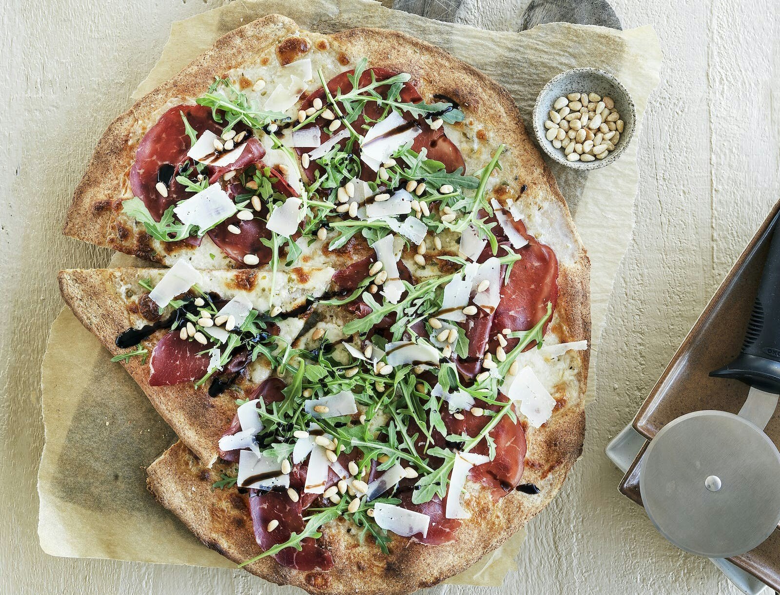 Pizza carpaccio med bresaola, rucola og parmesan