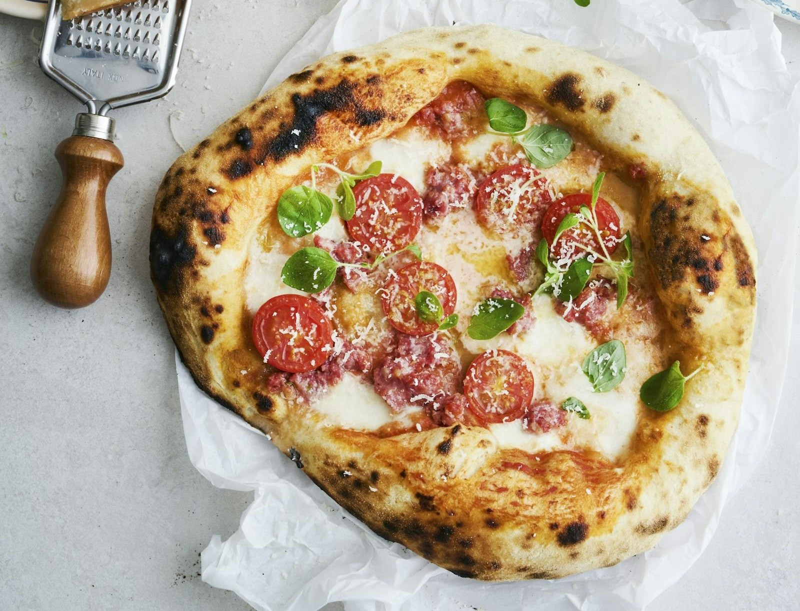 Pizza på grill med salsiccia og cherrytomater