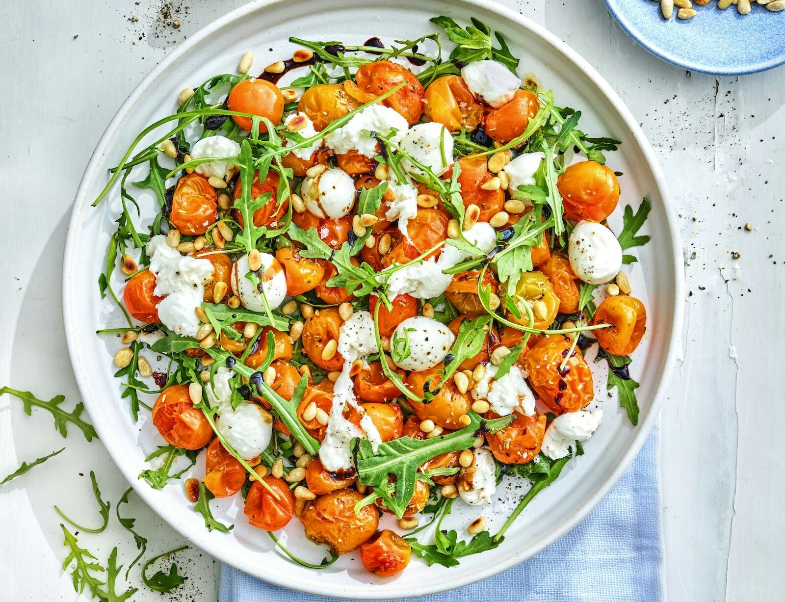 Rucolasalat med bagte tomater, mozzarella og pinjekerner