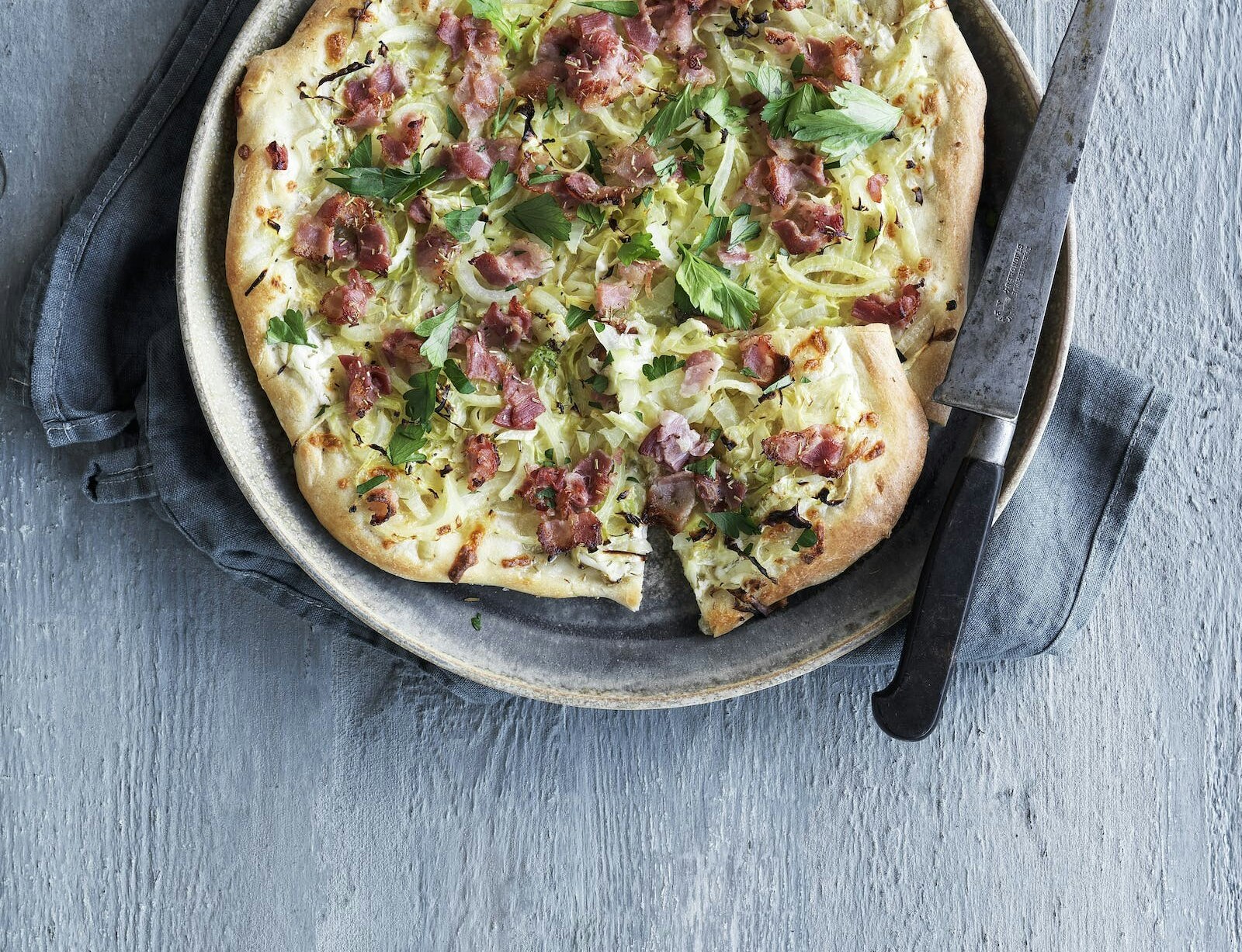 Tarte flambée med løg, spidskål og bacon