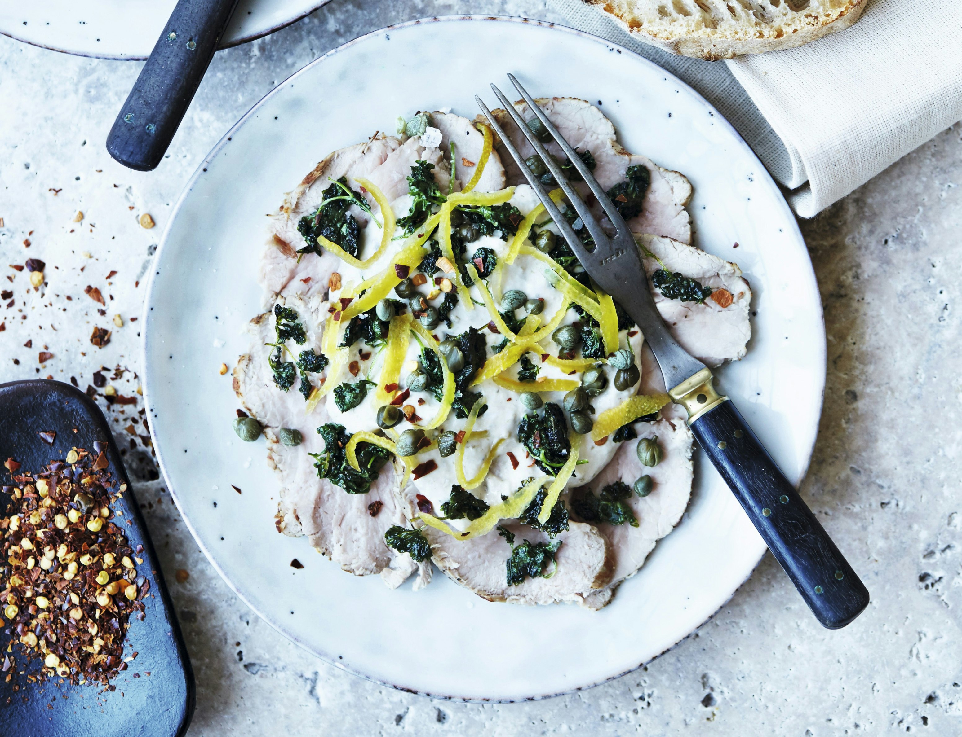 Vitello tonnato med kapers, stegt persille og syltede citronskaller